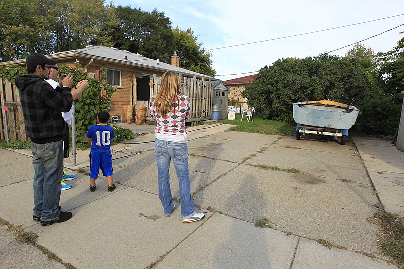 People photograph the driveway Wednesday in Roseville, Mich., where police plan to take soil samples Friday after a tipster said it could be the final resting place of missing Teamsters leader Jimmy Hoffa. Roseville Police Chief James Berlin says a man claims to have seen a body buried there approximately 35 years ago. Hoffa disappeared in suburban Detroit in 1975, and his remains haven't been found.