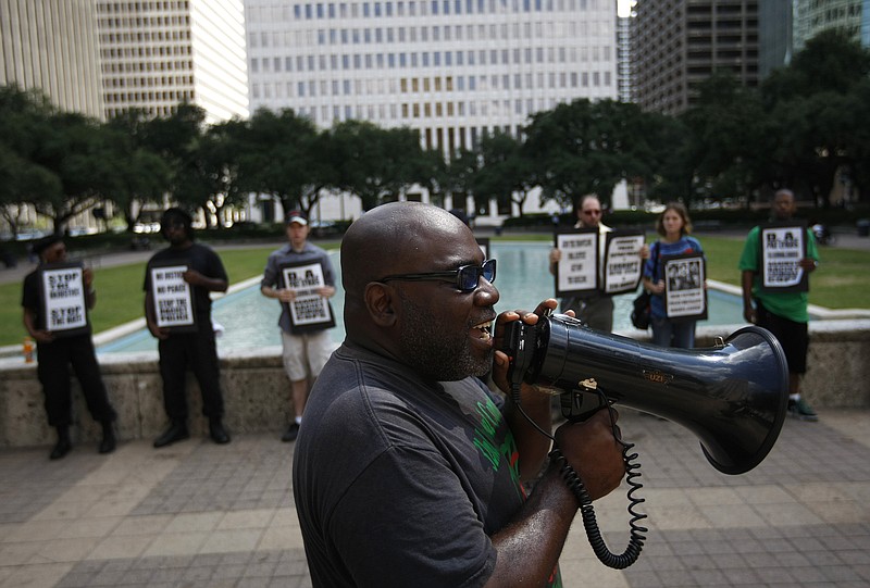 Activist Ali Muhammad with the National Black United Front leads a protest Tuesday of about 15 people calling for answers from city officials about why a police officer on Saturday fatally shot Brian Claunch outside City Hall in Houston. Claunch, a wheelchair-bound double amputee living in a group home for the mentally ill, was shot and killed by Houston Police in the early morning hours Saturday.