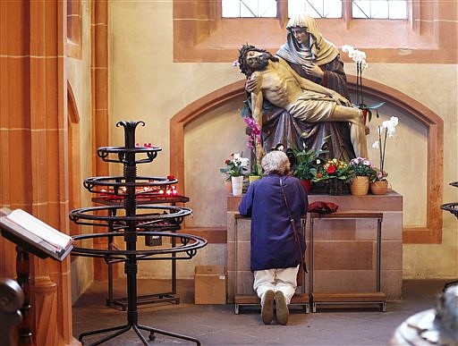 In this photo taken on Thursday, Sept. 27, 2012, a woman prays under a statue depicting Jesus and Mary, in the cathedral of Frankfurt, Germany. The road to heaven is paved with more than good intentions for Germany's 24 million Catholics. If they don't pay their religious taxes, they will be denied sacraments, including weddings, baptisms and funerals. A decree issued last week by the country's bishops cast a spotlight on the longstanding practice in Germany and a handful of other European countries in which governments tax registered believers and then hand over the money to the religious institutions.