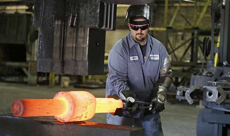 In this Thursday, Sept. 6, 2012, photo, Jack Knox positions a hot spindle being shape at Solmet Technologies in Canton, Ohio. U.S. manufacturing grew for the first time in four months, buoyed by a jump in new orders in September. The increase was a hopeful sign that the economy is improving. 