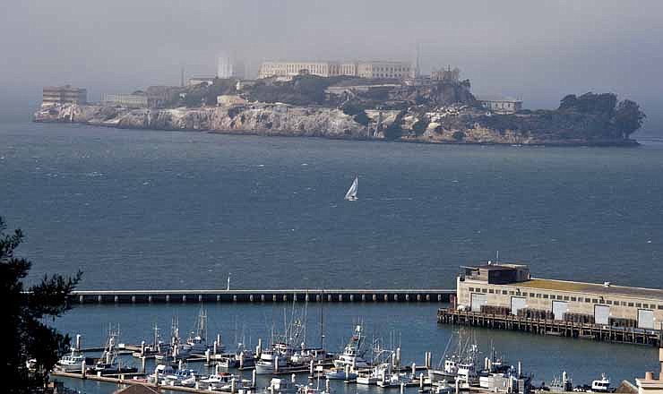 In this photo taken Thursday, Sept. 27, 2012, a sailboat makes its way past Alcatraz Island in San Francisco. San Francisco has a long history as a favorite site for filmmakers and the movie buffs who want to see the spots where their favorite scenes took place, from Fort Point under the Golden Gate Bridge where Jimmy Stewart saved Kim Novak in "Vertigo" to the steps of City Hall, where Sean Penn gave an impassioned speech in "Milk," to Alcatraz, stage for Clint Eastwood and many others.