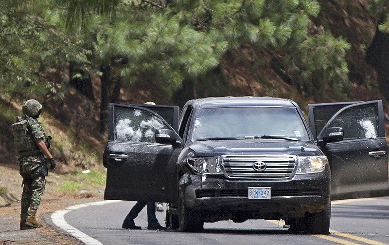 An armored U.S. embassy vehicle is checked by military personal after it was attacked by unknown assailants on the highway leading to the city of Cuernavaca, near Tres Marias, Mexico. A senior U.S. official says there is strong circumstantial evidence that Mexican federal police who fired on a U.S. embassy vehicle, wounding two CIA agents, were working for organized crime on a targeted assassination attempt.