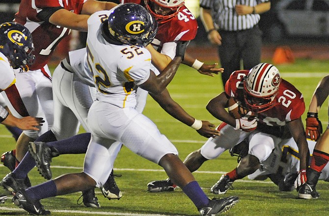 Jefferson City teammates John Carter (left) and Scott Stegeman (45) block for John Dement (20) during Friday night's game against Hickman at Adkins Stadium.