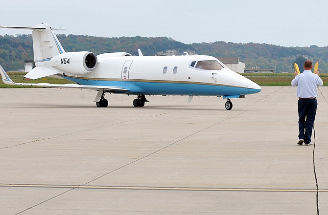 Line specialist Nick Haill directs a Lear Jet 60 for parking at the Jefferson City Memorial Airport.