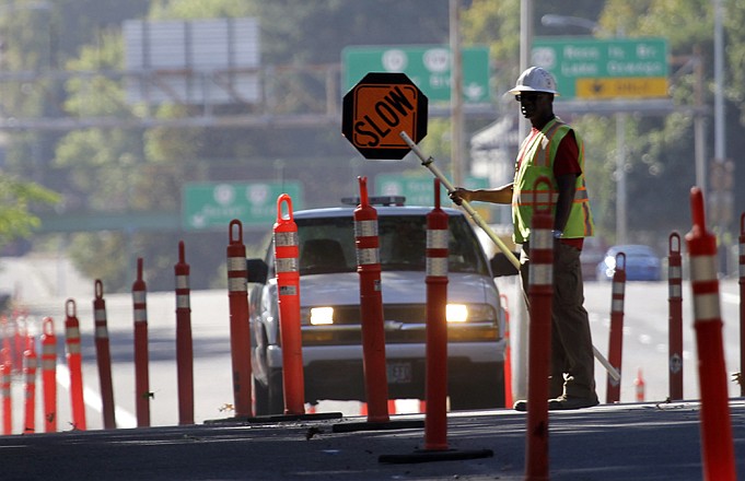A worker directs traffic for street construction in Portland, Ore., Friday. The Labor Department reported Friday the unemployment rate fell to 7.8 percent in September, a decline of 0.3 percentage point and the lowest since January 2009. The government said the economy created 114,000 jobs, about as expected, and generated 86,000 more jobs in July and August than first estimated.