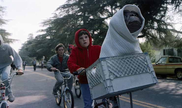 This undated publicity film image released by Universal Pictures shows Henry Thomas as Elliott and E.T. in a basket on a bicycle in a scene from director Steven Spielberg's "E.T.: The Extra-Terrestrial." In honor of the 30th anniversary of "E.T.," a digitally remastered feature film returns to theaters Oct. 3, 2012, along with a Blu-ray Anniversary Edition available Oct. 9. 