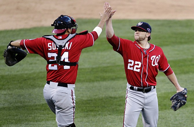 Nationals relief pitcher Drew Storen (right) and catcher Kurt Suzuki celebrate their 3-2 win over the Cardinals in Game 1 of their National League division series on Sunday in St. Louis.