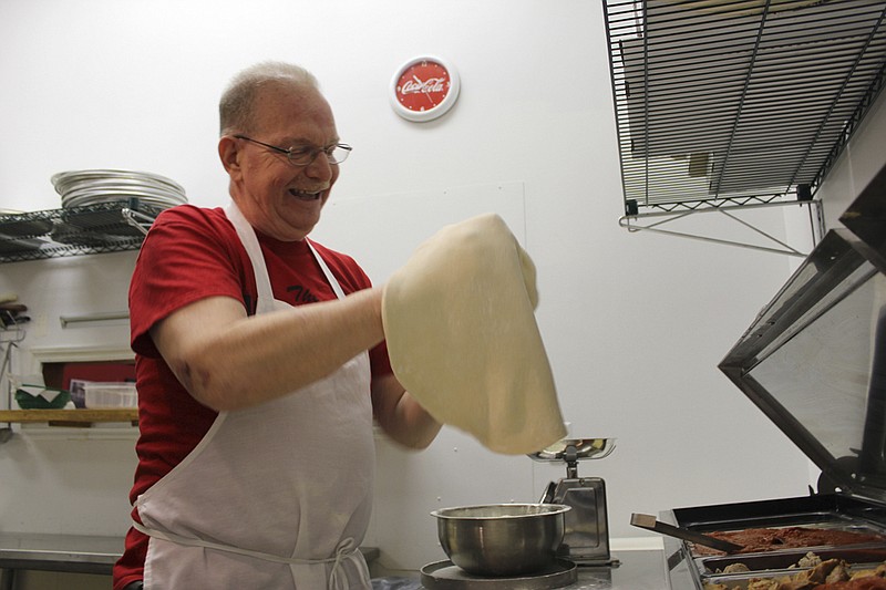 Brian Atkins prepares dough for one of Brooklyn Pizza's pizza specials this week: Fresh, plum tomatoes and red onions. Brooklyn Pizza features subs, calzones, house-made meatballs and sausage prepared fresh at Moser's with Brooklyn Pizza's recipe.