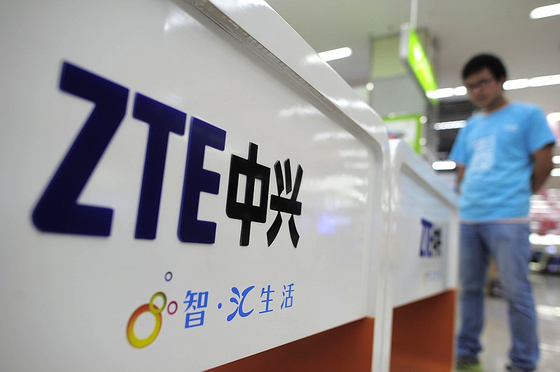 A salesperson stands at counters Monday selling mobile phones produced by ZTE Corp. at an appliance store in Wuhan, in central China's Hubei province. Eager to expand in the United States, China's biggest technology companies face American anxiety about security and rising Chinese competition.