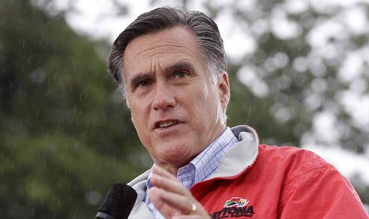 In this Sept. 14, 2012, photo, Republican presidential candidate, former Massachusetts Gov. Mitt Romney campaigns in the rain at Lake Erie College in Painesville, Ohio.