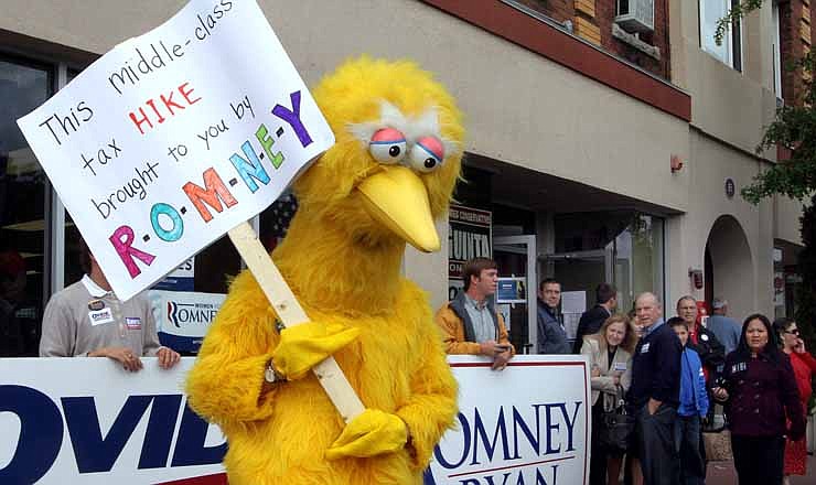 A person dressed up as Big Bird holds a sign against Republican presidential candidate, former Massachusetts Gov. Mitt Romney outside the Romney headquarters, Monday, Oct. 8, 2012 in Derry, N.H. where House Speaker John Boehner of Ohio was about to speak to supporters.