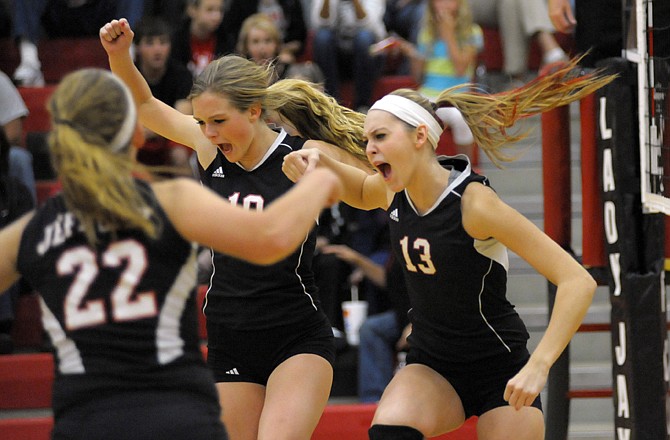 Jefferson City teammates Kylie Runzi (22), Sloan Pleus (center) and Madison Bond celebrate after winning a point in Tuesday's match against Sedalia Smith-Cotton at Fleming Fieldhouse.