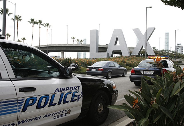 Airport police monitor the entrance of Los Angeles International Airport in Los Angeles in 2009. Yongda Huang Harris, 28, flying from Japan to Boston, was arrested Friday, during a stopover at Los Angeles International Airport, wearing a bulletproof vest and flame-resistant pants, and traveling with a suitcase full of weapon, U.S. Immigration and Customs Enforcement officials said Tuesday. 