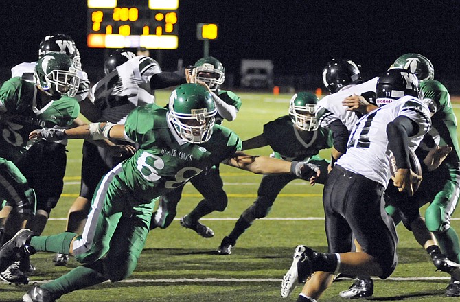 Corbin Singer of Blair Oaks reaches out toward a Warsaw runner during last Friday's game at the Falcon Athletic Complex.