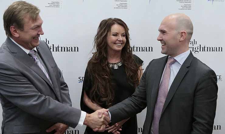 From left, Russian Space agency Head of Department Human Space Flight Programs Aleksei Krasnov, British soprano singer Sarah Brightman, and Space Adventures CEO Eric Anderson pose for photographers after a news conference in Moscow, Russia, Wednesday, Oct. 10, 2012 to announce that Brightman will become the first-ever global recording artist to take a spaceflight, teaming up with Space Adventures for a journey to the International Space Station (ISS).