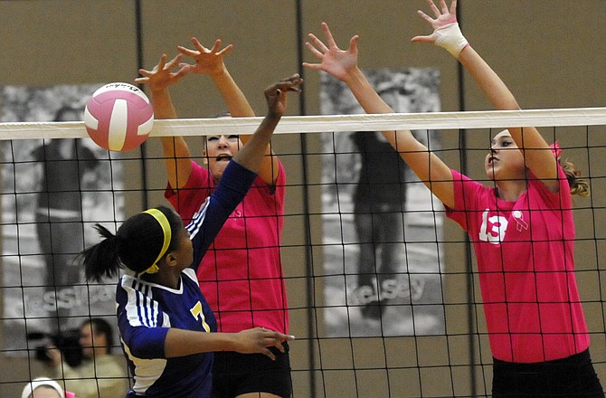 Jefferson City's Alicia Woods (left) and Madison Bond (right) block a spike by Hickman's Madison Waggoner on Thursday at Fleming Fieldhouse. The Jays won the match 2-0.