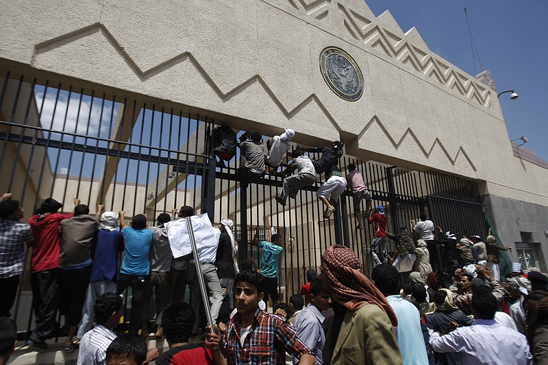 Yemeni protestors climb the gate of the U.S. Embassy during a protest about a film ridiculing Islam's Prophet Muhammad, in Sanaa, Yemen. A drive-by shooting that killed a top Yemeni security official who worked at the U.S. Embassy in Sanaa on Thursday raises concern that al-Qaida militants here are bouncing back and getting bolder.