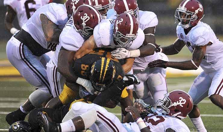 A host of Alabama defenders pulls down Missouri's Jimmie Hunt as he returns a punt during the first half of an NCAA college football game, Saturday, Oct. 13, 2012, in Columbia, Mo. 