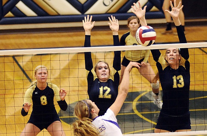 Helias' Brittney Engelbrecht (12) and Anna Murphy go up for a block on Camdenton's Megan Weber during Monday's match at Rackers Fieldhouse.