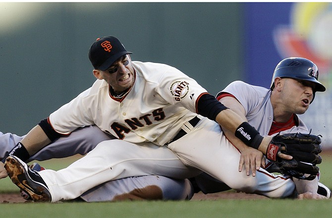 
Giants second baseman Marco Scutaro gets tied up with the Cardinals' Matt Holliday on a double play attempt during the first inning of Game 2 of the National League championship series Monday in San Francisco.