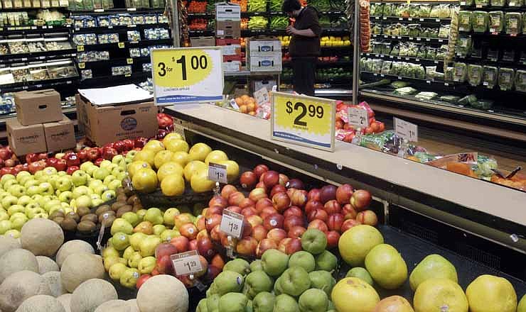 In this March 2011, photo, Jake Polson works in the fruit and vegetable department at a Kroger Co. supermarket in Cincinnati.