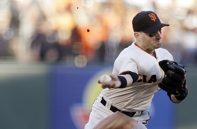 Giants second baseman Marco Scutaro grimaces as his leg is caught under Matt Holliday on a double play attempt during the first inning of Game 2 of the National League championship series Monday in San Francisco.