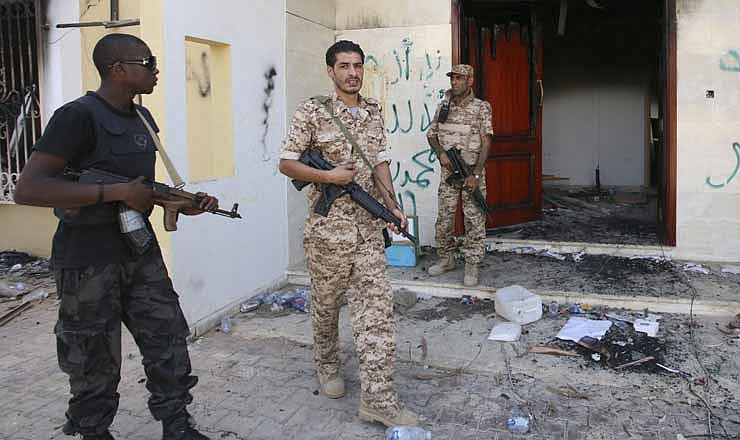 In this Sept. 14, 2012 file photo, Libyan military guards check one of the burnt out buildings at the U.S. Consulate in Benghazi, Libya, during a visit by Libyan President Mohammed el-Megarif to express sympathy for the death of American ambassador to Libya Chris Stevens and his colleagues in the Sept. 11, 2012 attack on the consulate. 