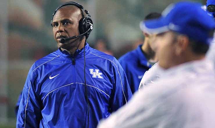 Kentucky coach Joker Phillips, left, watches from the sideline during the second quarter of an NCAA college football game against Arkansas in Fayetteville, Ark., Saturday, Oct. 13, 2012.