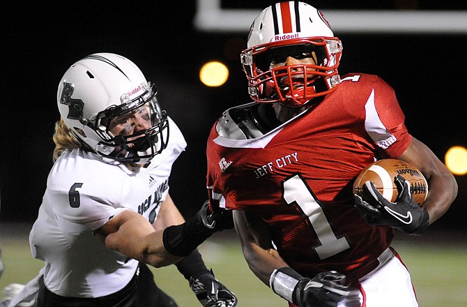 Jefferson City running back Rayshawn Williams tries to break free from the grip of Rock Bridge safety West Wilson while picking up big yardage for a first down in the fourth quarter of Friday night's matchup at Adkins Stadium.