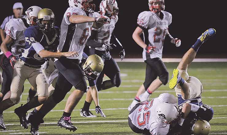

Helias wide receiver Andrew Schaumburg is tackled by Hannibal's (#25) during the homecoming at Adkins Stadium Saturday night.
