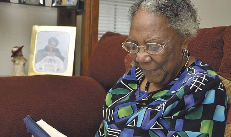 Luvenia Washington reads a passage from her Bible at home. With the help of ABLE in Jefferson City, Luvenia learned to read so she could read religious writings.