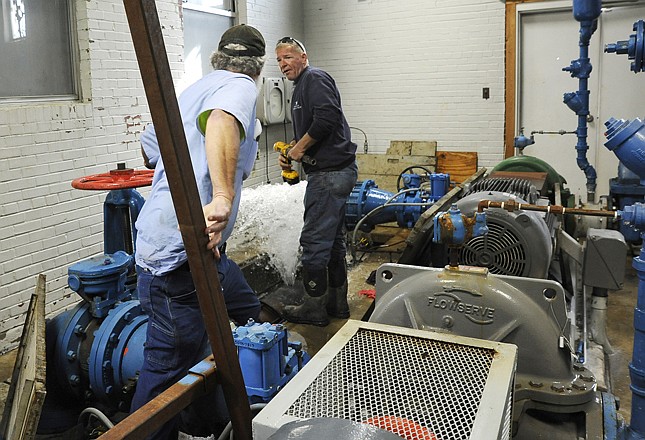 As the water spurt suddenly intensifies, workers rush back to the spot where a pressure bypass gave way Tuesday morning at the Missouri American Water High Service Building. Four pumps located in the building generate the water pressure needed for the water system. Crews clamped a leak on an opposing line but then had to wait for an additional saddle clamp to arrive from out of town. 