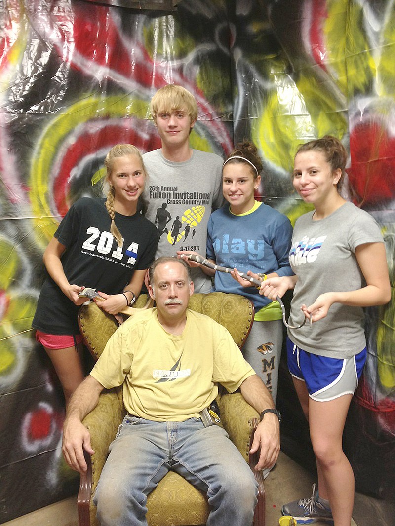 (Standing, from left) South Callaway cross country runners Abigail Luebbert, Tristan Peneston, Taylor Howard and Andi Rodriguez and (seated) Mokane Lions Club President Bryan Rogers all have been working on the Mokane Haunted Hall. The haunted house, to be held Oct. 27, 28 and 31 at the Mokane Lions Club, will serve as a fundraiser for both groups.