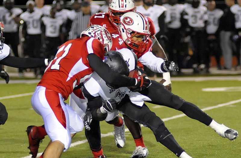 Jefferson City's Eric Hofmann (left) and Jordan Robinson team up to stop Fort Zumwalt West's Teddy Williamson in the backfield during Friday's game at Adkins Stadium.