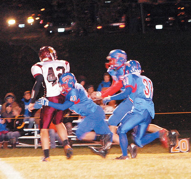 California's Luke Burger (41), Scott Porter (31) and Nathan Goans (65) team up to bring down Missouri Military Academy quarterback Jacob Priester to end his run in the first quarter of the Class 3 District 6 football game Thursday at Riley Field. California defeated MMA 71-0 in two quarters. 