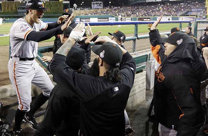 San Francisco Giants' Hunter Pence is congratulated in the dugout after scoring on a triple by Gregor Blanco during the second inning of Game 3 of baseball's World Series against the Detroit Tigers Saturday, Oct. 27, 2012, in Detroit. 