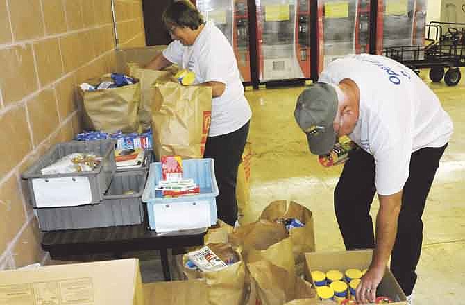 
Neil and Brenda Smith sort items donated at various businesses at "Santa's Hut" in the Coca-Cola Community Room. The item are being collected and sorted for Operation Guardian Angel.