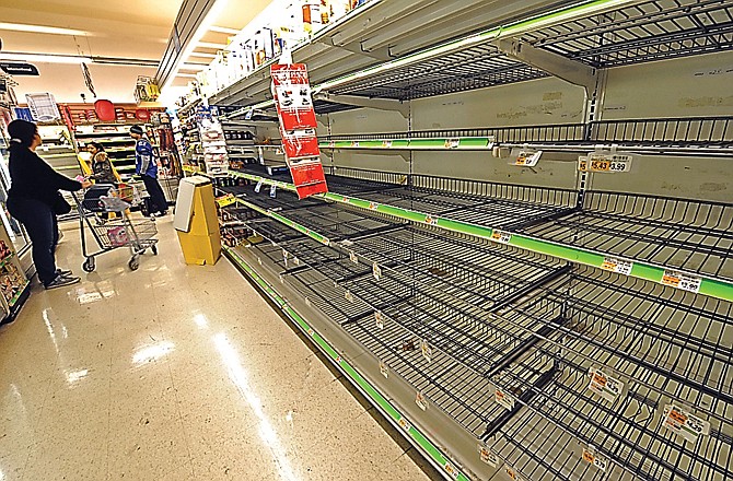 A shopper finds the bread shelves empty at a Manhattan supermarket Sunday as residents stocked up ahead of a superstorm bearing down on the East Coast.