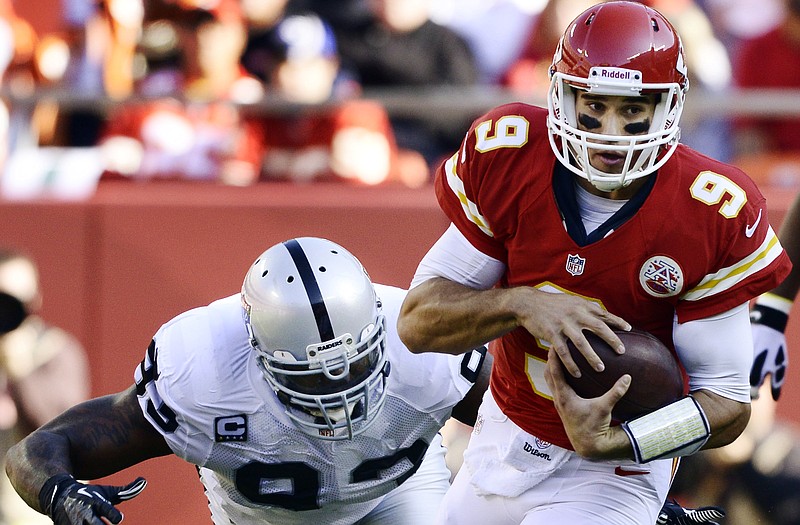 Chiefs quarterback Brady Quinn (9) is tackled by Raiders defensive tackle Tommy Kelly during the first half Sunday at Arrowhead Stadium in Kansas City. Quinn left the game during the first quarter due to what the team called a "head injury." 