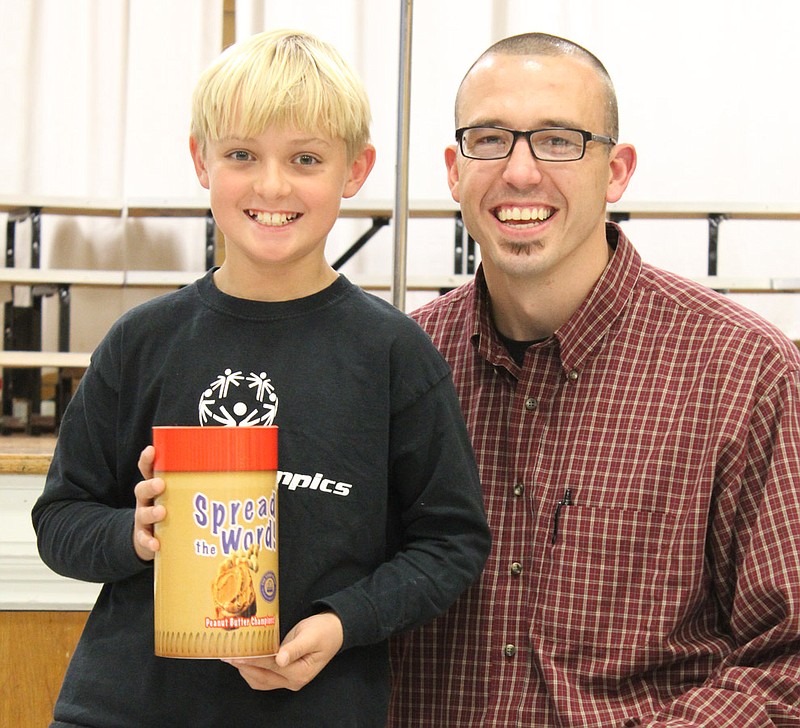 Aiden Petterson, 10, poses with a peanut butter trophy alongside Food Bank of Central and Northeast Missouri Regional Coordinator of Special Events Chris Sisk. Petterson helped start a peanut butter drive at Bartley Elementary School that collected 180 jars of peanut butter for the Buddy Pack program.