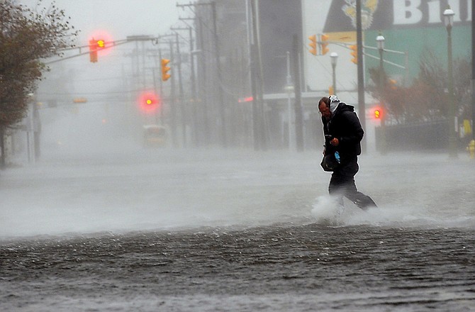Michael Wirtz, of Wilmington, Del., braves flood waters and high winds that arrive with Hurricane Sandy in Atlantic City, N.J.