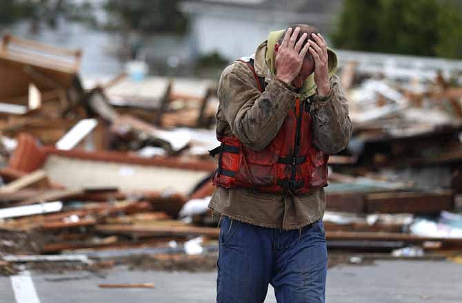 Brian Hajeski, 41, of Brick, N.J., reacts after looking at debris of a home that washed up on to the Mantoloking Bridge the morning after superstorm Sandy rolled through, Tuesday, Oct. 30, 2012, in Mantoloking, N.J. Sandy, the storm that made landfall Monday, caused multiple fatalities, halted mass transit and cut power to more than 6 million homes and businesses.