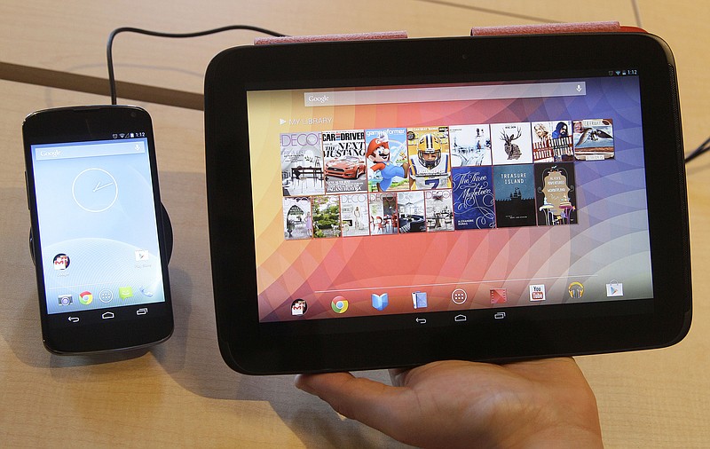 The Nexus 4 smartphone, left and the Nexus 10 tablet are shown Monday by Randall Safara of Google at a Google announcement in San Francisco. The devices announced Monday include the latest in Google's line of Nexus smartphones and a larger version of the 7-inch tablet that the company began selling in July under the Nexus brand.