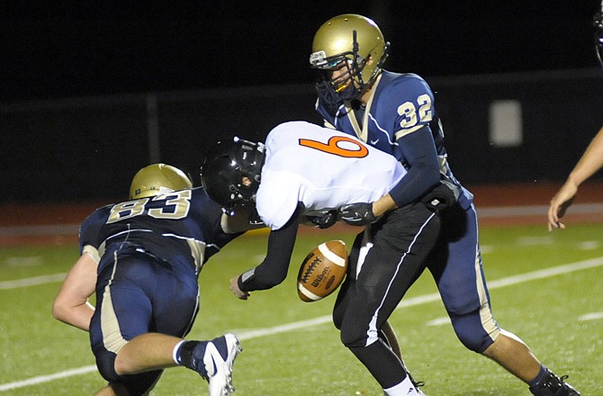 Helias teammates Hale Hentges (83) and Jon Wildhaber (32) force a fumble during in last Thursday night's game against Kirksville at Adkins Stadium.