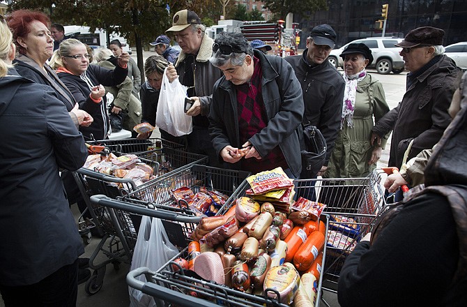 A customer browses food piled into shopping carts on Brighton Beach Avenue on Wednesday in the Brooklyn borough of New York.