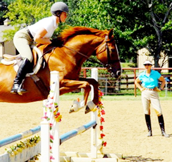 Melanie Smith Taylor watches a student perform during one of her hunter/jumper clinics.