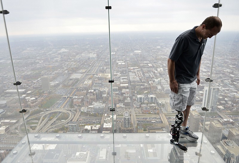 Zac Vawter, fitted with an experimental "bionic" leg, looks down from the Ledge at the Willis Tower in Chicago. Vawter is training for the world's tallest stair-climbing event where he'll attempt to climb 103 flights to the top of the Willis Tower using the new prosthesis.