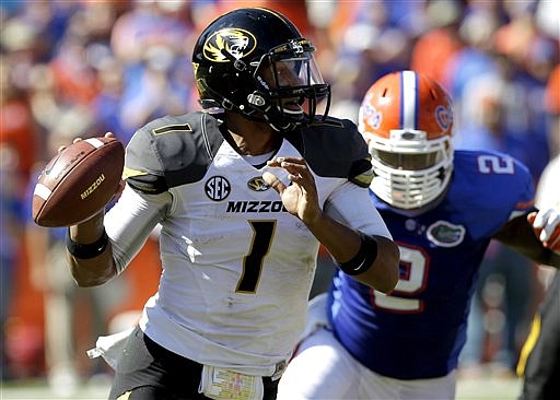 Missouri quarterback James Franklin (1) looks for a receiver as he scrambles away from Florida defensive lineman Dominique Easley (2) during the first half of an NCAA college football game, Saturday, Nov. 3, 2012, in Gainesville, Fla.