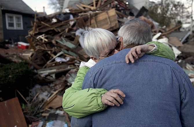 Sheila and Dominic Traina hug in front of their home which was demolished during Superstorm Sandy in Staten Island, N.Y., Friday, Nov. 2, 2012. 