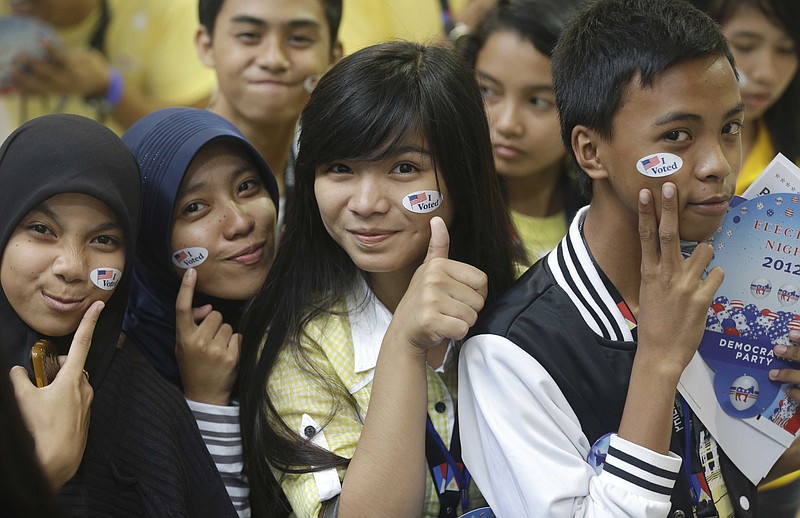 Muslim students pose before a throng of photographers shortly after "voting" in the mock U.S. election at a shopping mall Wednesday at suburban Quezon City, Philippines. Filipinos participated in a mock U.S. elections between President Barack Obama and Republican challenger Mitt Romney which was organized by the U.S. Embassy in Manila. 